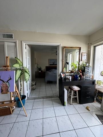 A room with white tile floors leads through a doorway into a bedroom — 2000 Biarritz Dr # 404, Miami Beach FL 33141, MIAMI BEACH, FL