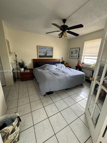 A bedroom features a large bed, tiled floors, a ceiling fan, and a window with blinds — 2000 Biarritz Dr # 404, Miami Beach FL 33141, MIAMI BEACH, FL