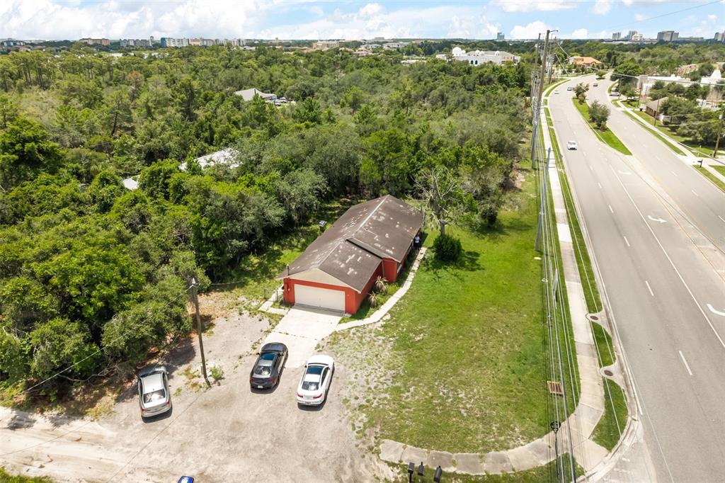 An aerial view shows a red house with a garage and three cars parked outside — 11253 S APOPKA VINELAND ROAD, ORLANDO, FL