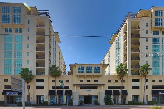 A multi-story apartment building with ground-floor retail spaces and two symmetrical residential towers — 1227 E MADISON STREET UNIT 601, TAMPA, FL