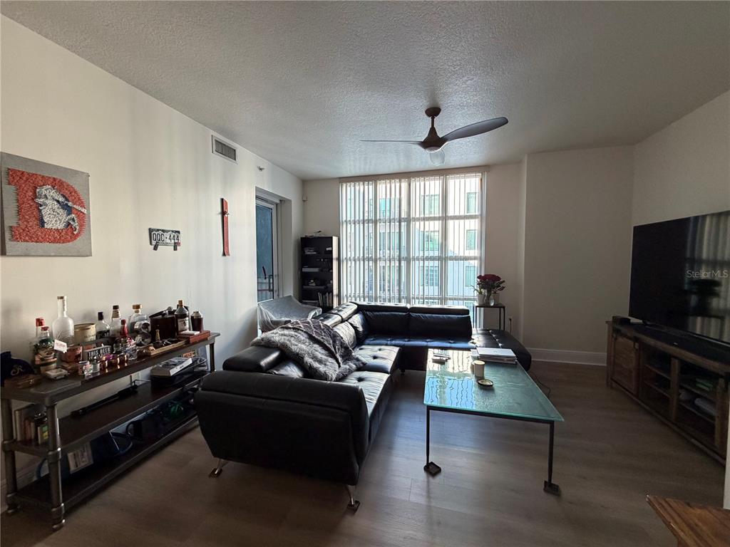A living room features a black sectional sofa, a glass coffee table, and a bar console — 1227 E MADISON STREET UNIT 601, TAMPA, FL