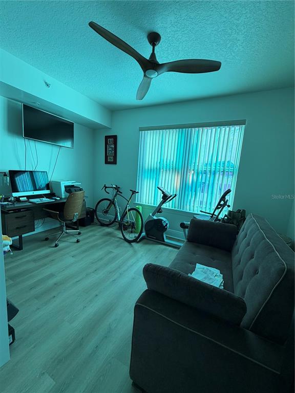 A home office featuring a desk, exercise equipment, and a sofa under a ceiling fan — 1227 E MADISON STREET UNIT 601, TAMPA, FL