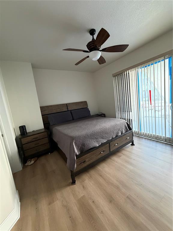 A bedroom features a wooden bed frame, a ceiling fan, and sliding glass doors — 1227 E MADISON STREET UNIT 601, TAMPA, FL