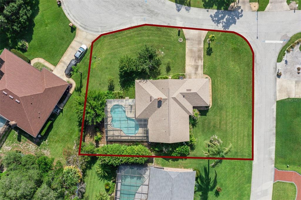 An aerial view shows a house with a screened pool on a corner lot — 4 BASS LAKE DRIVE, DEBARY, FL