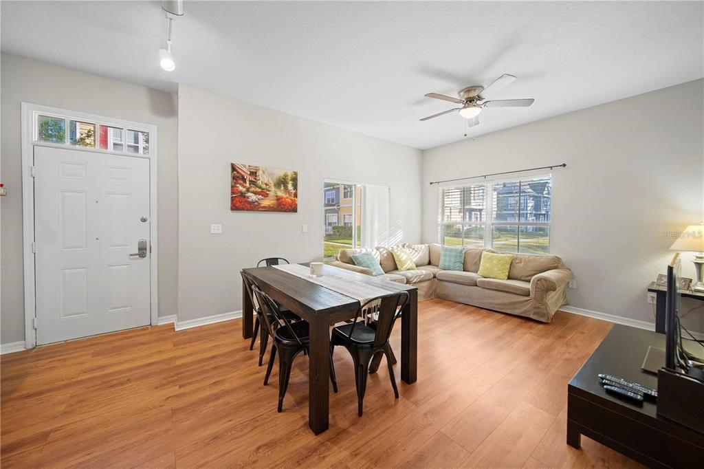 A living and dining area features wood-look flooring, a sectional sofa, and a dining table — 2601 GALA ROAD S UNIT 31-108, KISSIMMEE, FL