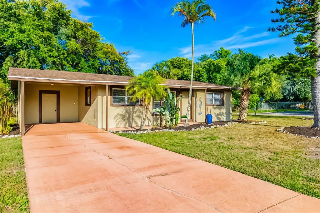 A single-story house with a carport, tan stucco exterior, and a paved driveway — 4219 35TH STREET W, BRADENTON, FL