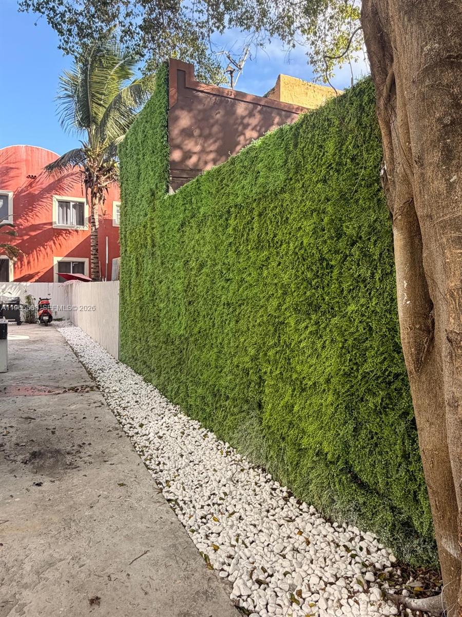 A tall artificial green wall runs alongside a white gravel path next to a building — 337 SW 10th Ave, Miami FL 33130, MIAMI, FL