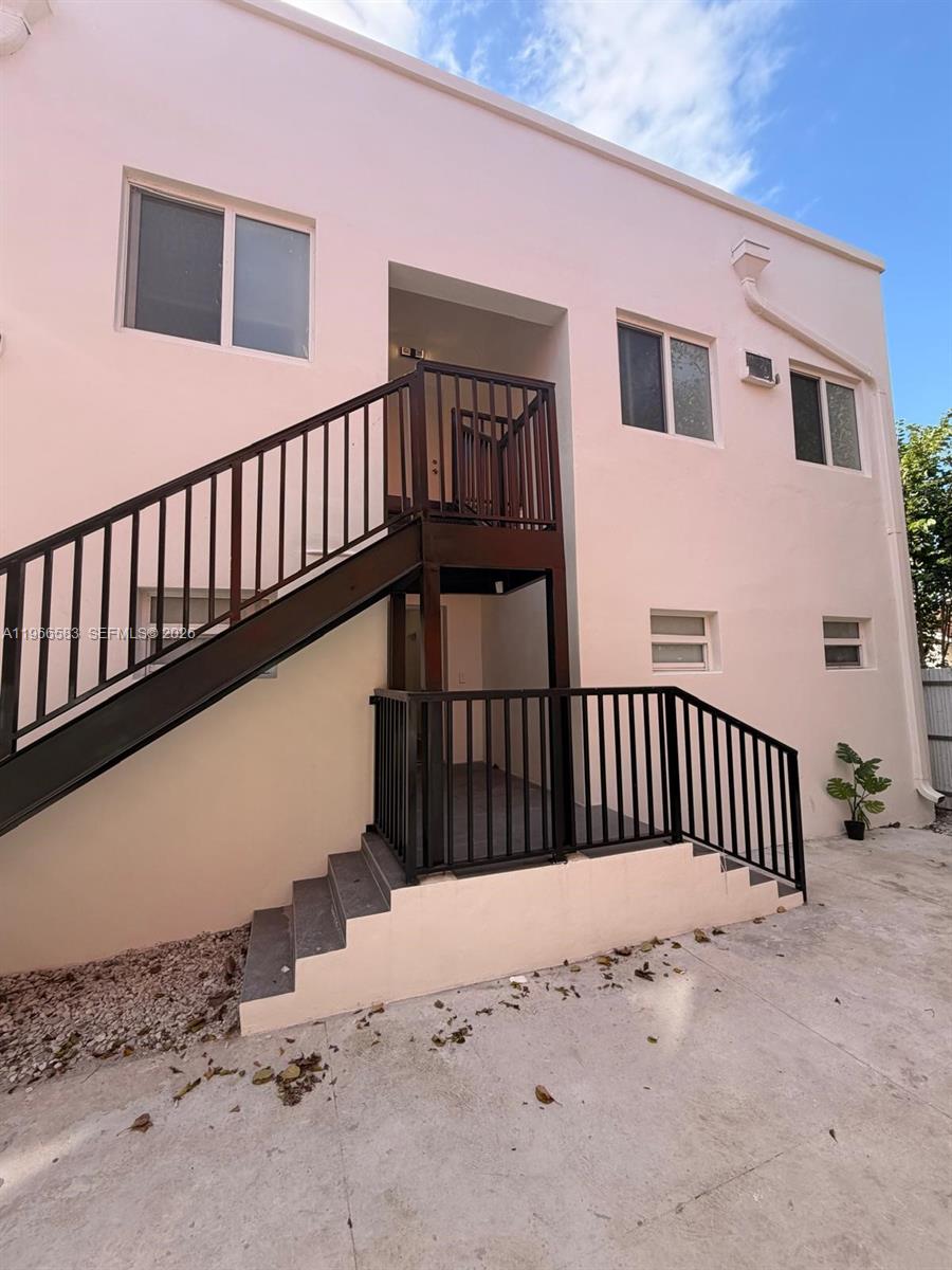 An exterior view of a two-story building with a pink facade and black metal stairs — 337 SW 10th Ave, Miami FL 33130, MIAMI, FL