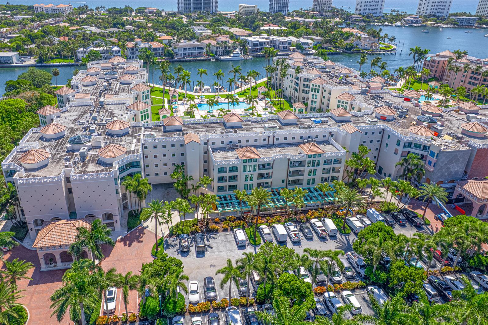 An aerial view shows a large resort complex with a pool, parking lot, and waterfront — 100 SE 5th Avenue # 412, Boca Raton FL 33432, BOCA RATON, FL