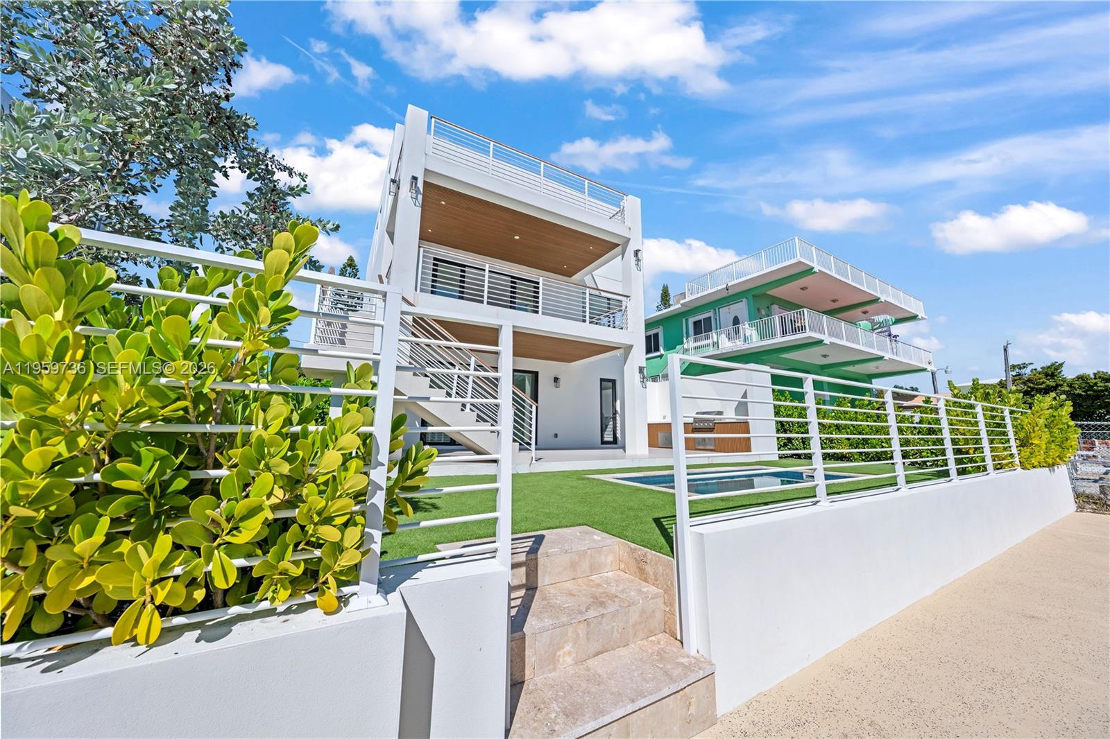 A modern white house with balconies and a pool sits behind a gated fence — 124 Orchid St, Plantation Key FL 33070, PLANTATION KEY, FL