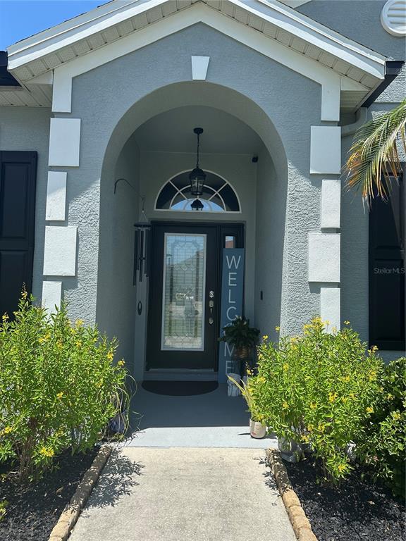 The exterior front entrance features a gray arched entryway, a dark door, and landscaping — 2500 CORBYTON COURT, ORLANDO, FL