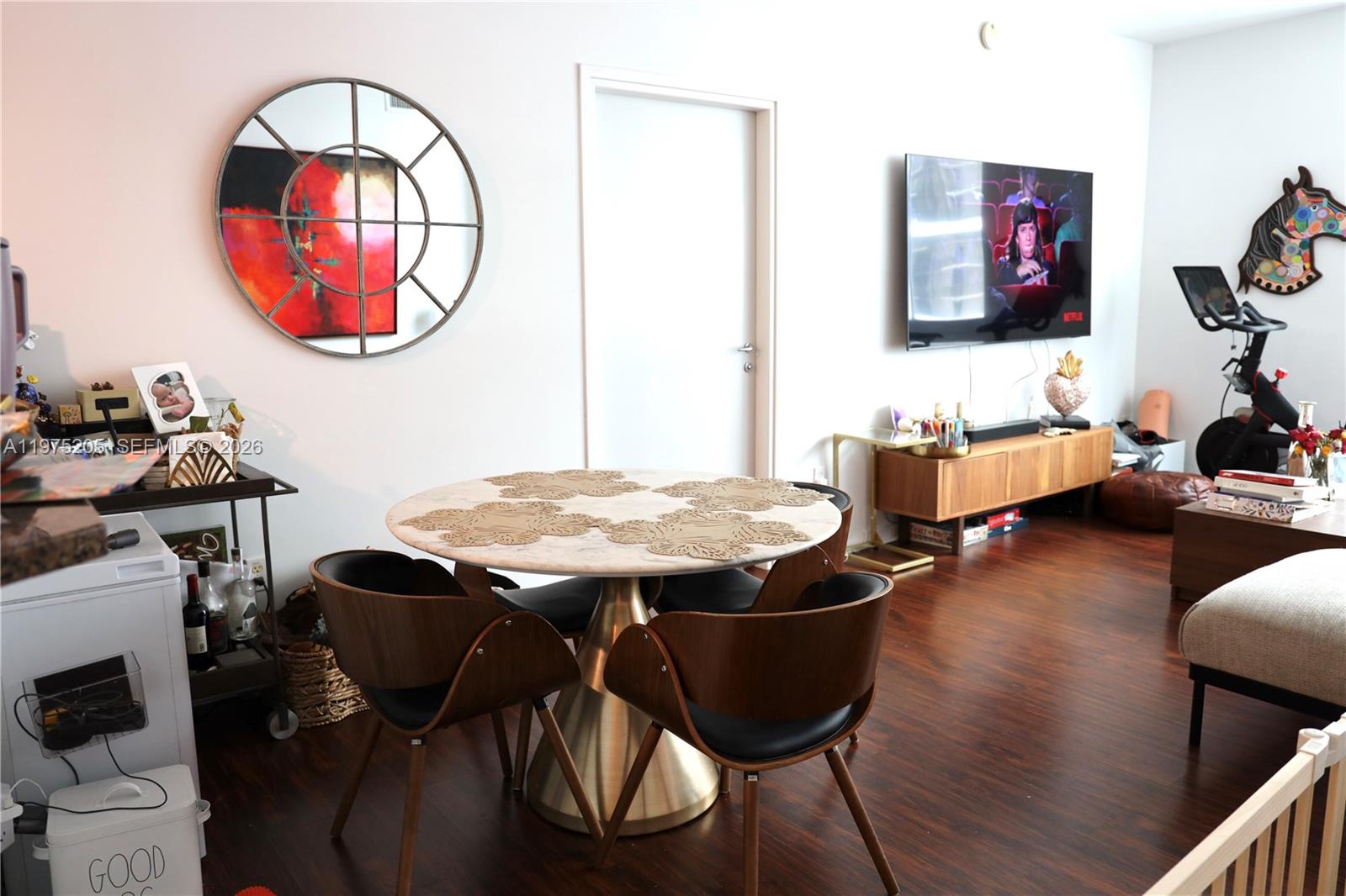 A dining area with a round marble table and wooden chairs sits beside a living room — 300 S Biscayne Blvd # 3504, Miami FL 33131, MIAMI, FL