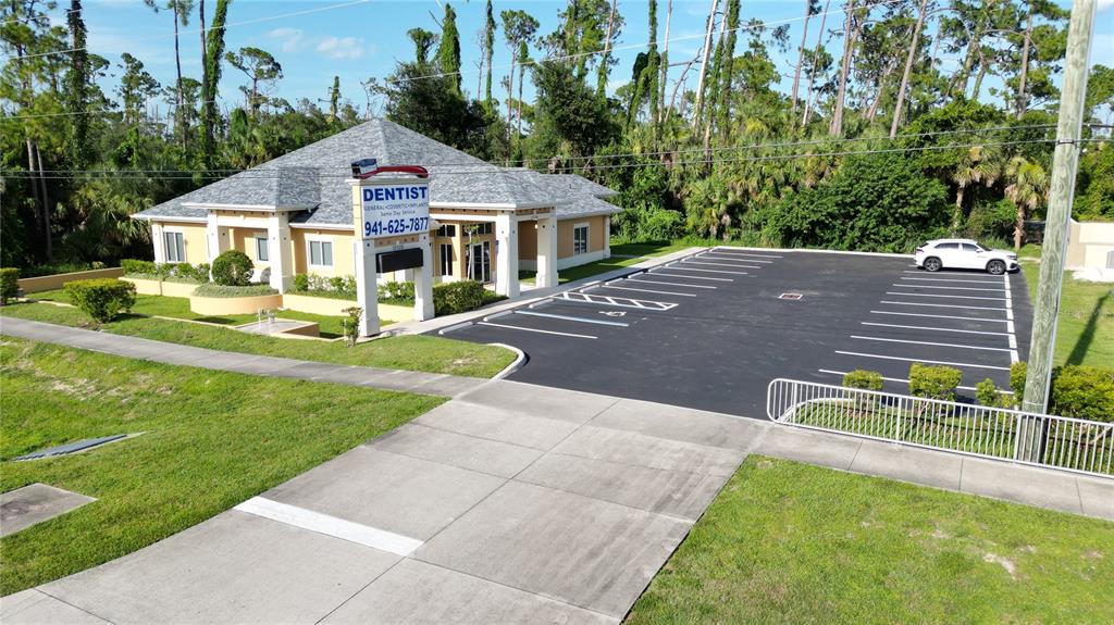 An aerial view shows a dental office building with a parking lot and surrounding trees — 17178 TOLEDO BLADE BOULEVARD, PORT CHARLOTTE, FL