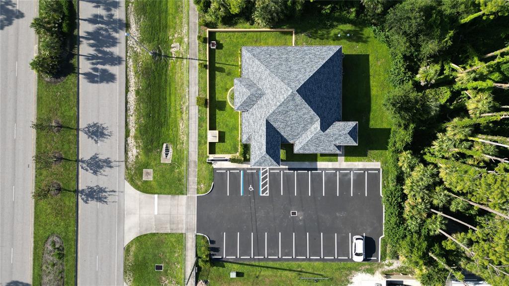 An aerial view shows a commercial building with a parking lot and surrounding green space — 17178 TOLEDO BLADE BOULEVARD, PORT CHARLOTTE, FL