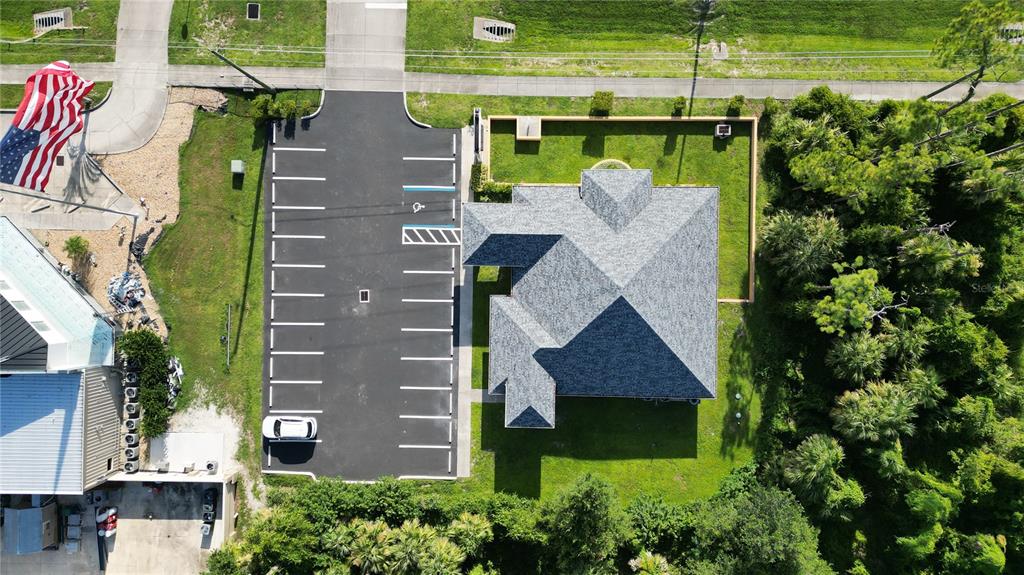 An aerial view shows a building with a gray roof, an adjacent parking lot, and landscaping — 17178 TOLEDO BLADE BOULEVARD, PORT CHARLOTTE, FL