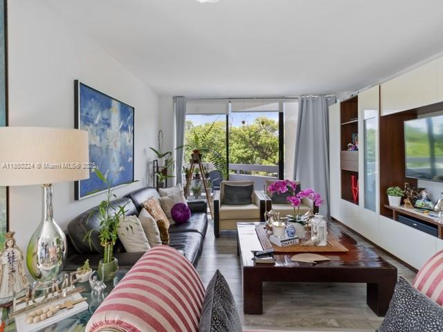 A living room features a dark leather sofa, a large wooden coffee table, and balcony views — 2501 Brickell Ave # 307, Miami FL 33129, MIAMI, FL