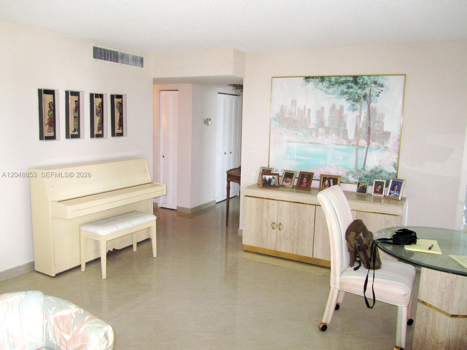 A room features a piano, a dining set, and a credenza with framed photos — 1833 S Ocean Dr # 911, Hallandale Beach FL 33009, HALLANDALE BEACH, FL