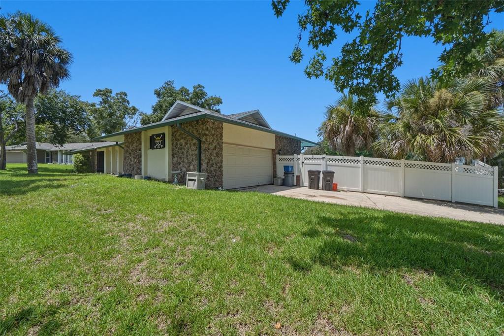 A single-story house with a stone facade, a garage, and a white vinyl privacy fence — 701 MILAN COURT, ALTAMONTE SPRINGS, FL