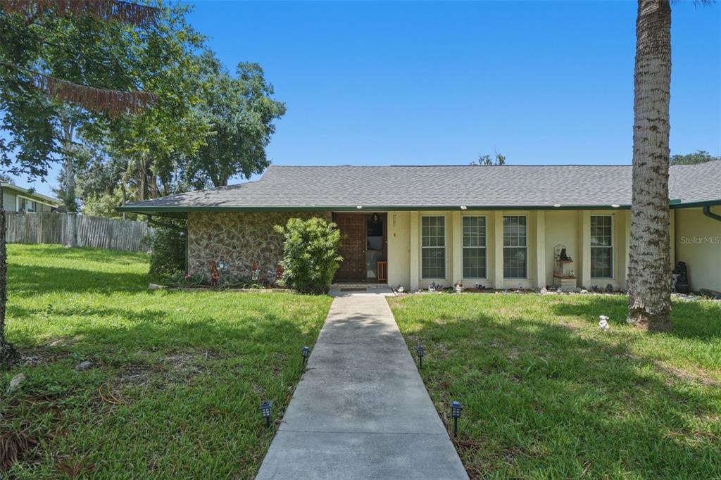 A single-story house with a stone facade, a concrete walkway, and a palm tree — 701 MILAN COURT, ALTAMONTE SPRINGS, FL