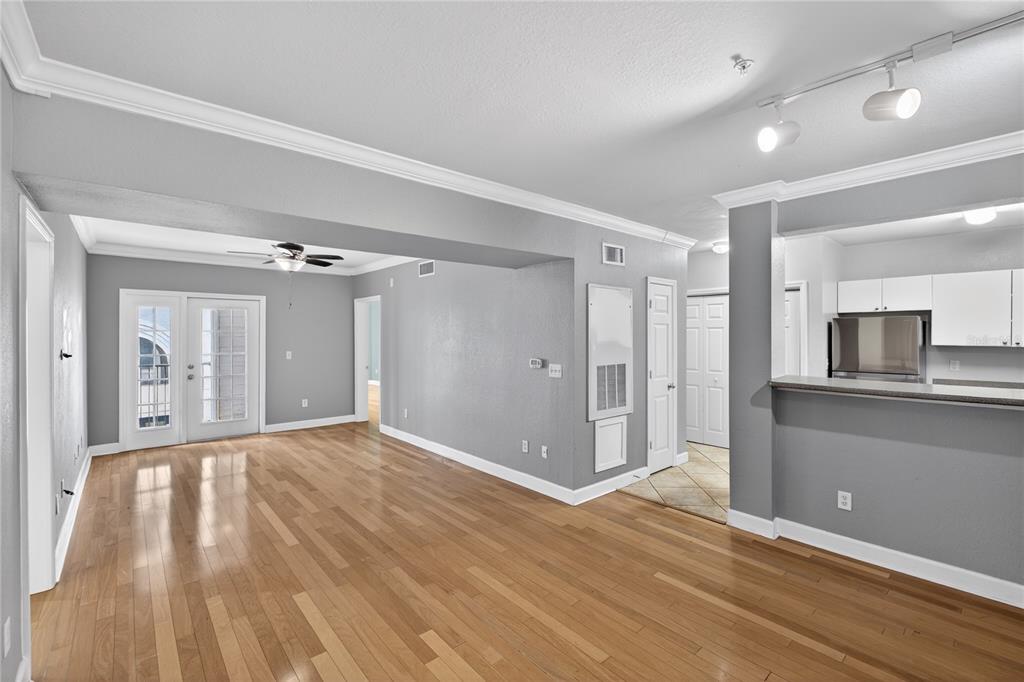 An open-concept living area with hardwood floors, gray walls, and an adjacent kitchen breakfast bar — 300 E SOUTH STREET UNIT 2014, ORLANDO, FL