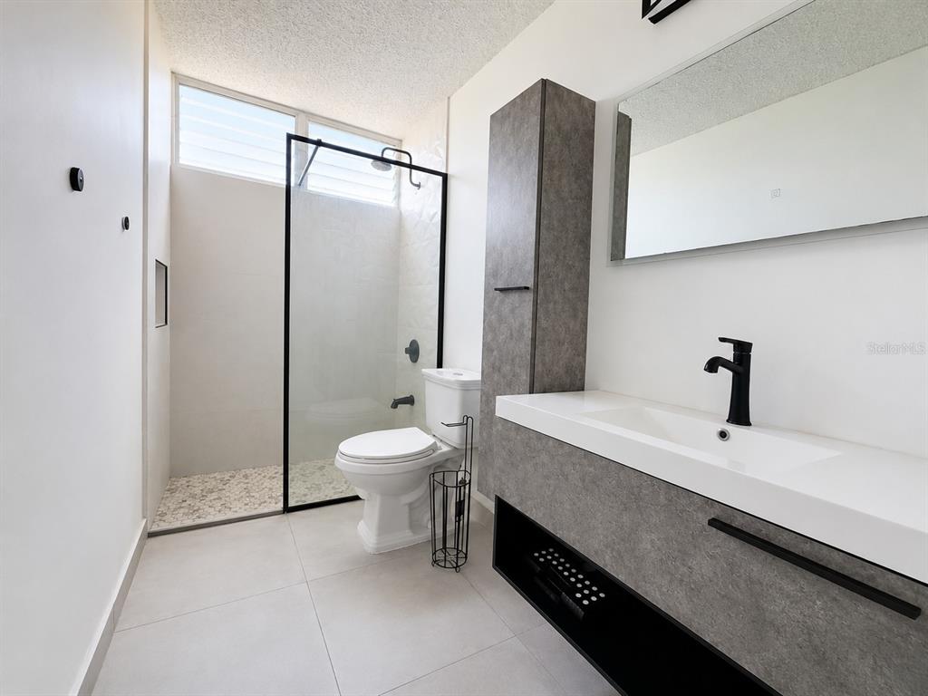 A modern bathroom features a walk-in shower, a floating vanity, and a toilet — CARR 844 1D-5 SAN JUAN CHALETS APT. 8050, SAN JUAN, PR