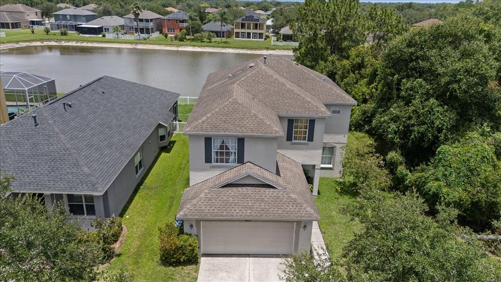 An aerial view shows a two-story house with a shingled roof and a garage — 9467 LEATHERWOOD AVENUE, TAMPA, FL