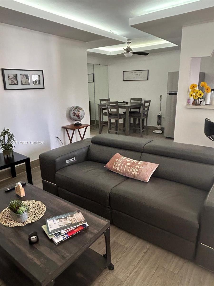A living room with a gray sofa and coffee table leads into a dining area — 16900 NE 14th Ave # 209, Miami FL 33162, MIAMI, FL