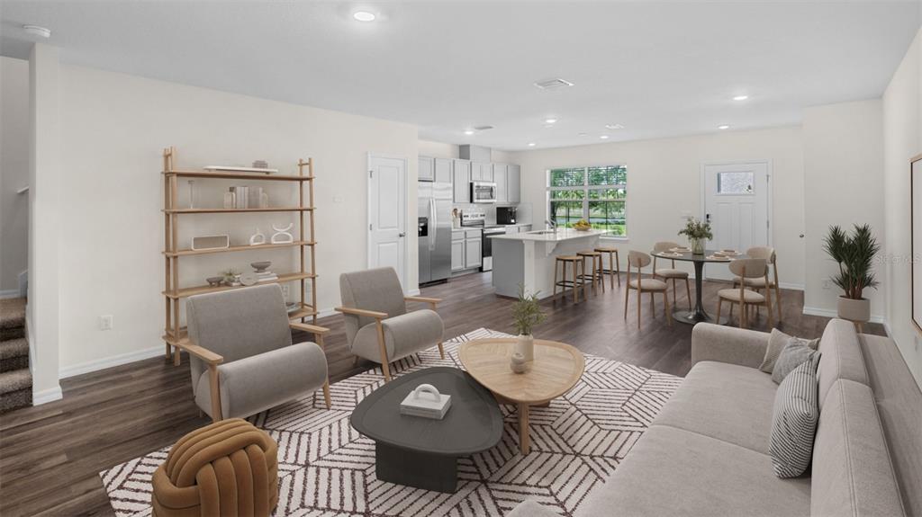 An open-concept living room and kitchen featuring light walls, dark wood floors, and modern furniture — 16570 BARBOURS CREEK WAY, WINTER GARDEN, FL