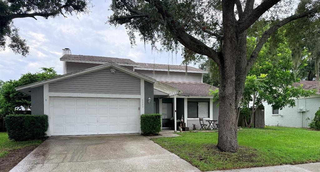 A two-story house with a gray exterior, a two-car garage, and a large oak tree — 4303 ELLENVILLE PLACE, VALRICO, FL