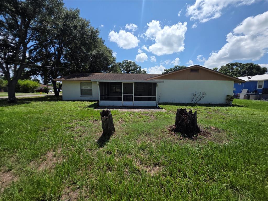 A single-story house with a screened-in porch and two tree stumps in the yard — 2312 7TH ST E, BRADENTON, FL