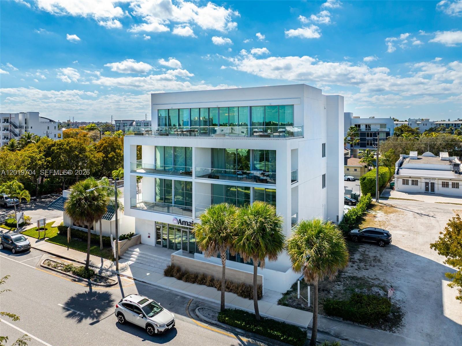 A modern four-story white building with glass balconies and palm trees in front — 246 NE 6th Ave Ave PH, Delray Beach FL 33483, DELRAY BEACH, FL