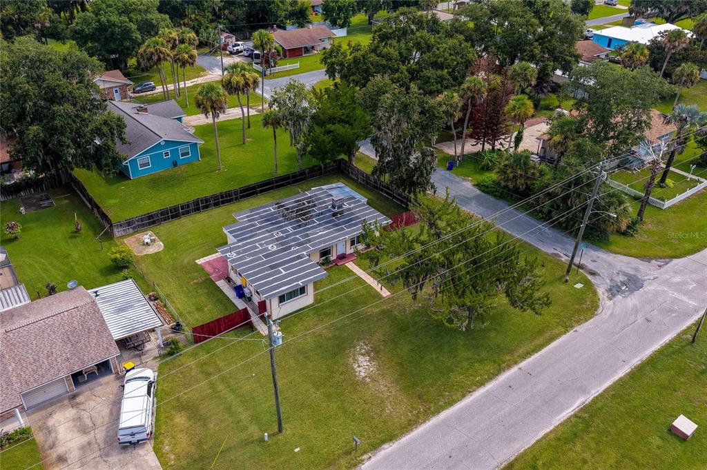 An aerial view shows a single-story house with a large solar panel array on its roof — 1101 16TH STREET, EDGEWATER, FL