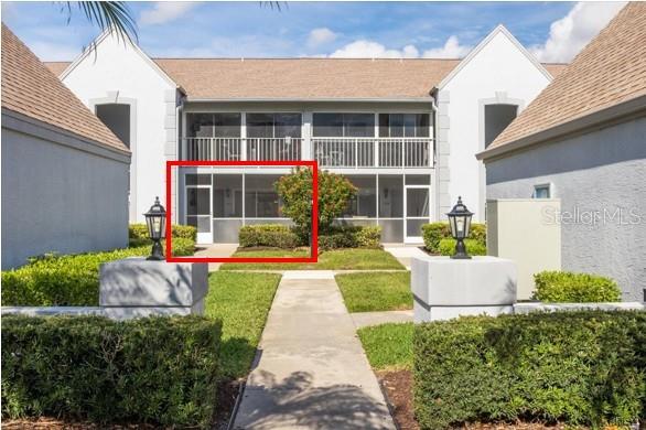 A ground-level screened patio is highlighted in red in front of a two-story building — 6713 STONE RIVER ROAD UNIT 103, BRADENTON, FL