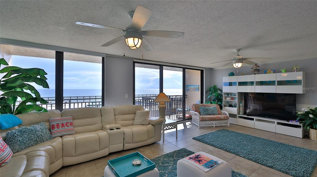 A living room features a white sectional sofa, two ceiling fans, and a large ocean view — 4139 S ATLANTIC AVENUE UNIT B204, NEW SMYRNA BEACH, FL