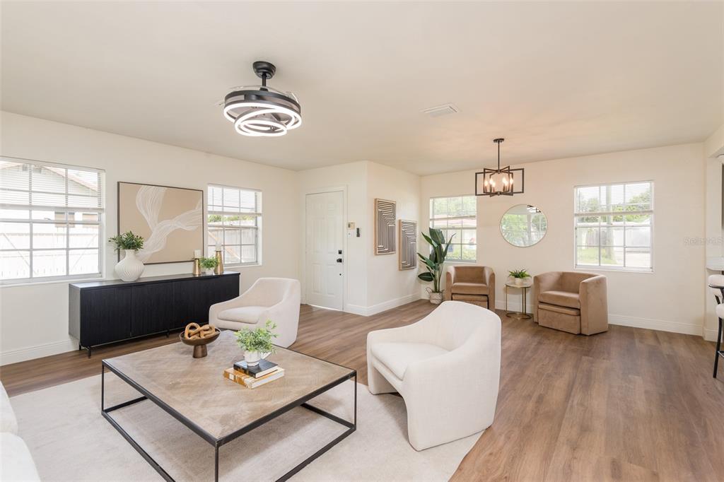 A bright living room features light wood floors, white walls, and modern furniture — 2421 LINSEY STREET, TAMPA, FL