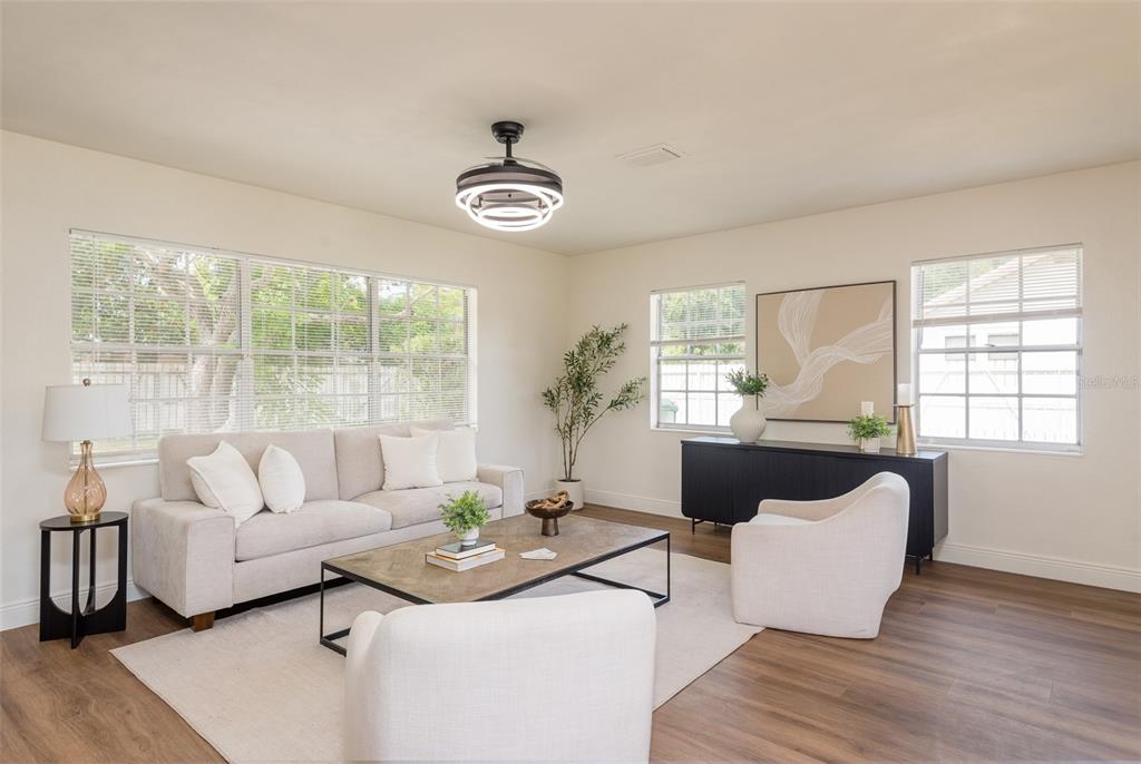 A living room features a light-colored sofa, two armchairs, a coffee table, and wood flooring — 2421 LINSEY STREET, TAMPA, FL