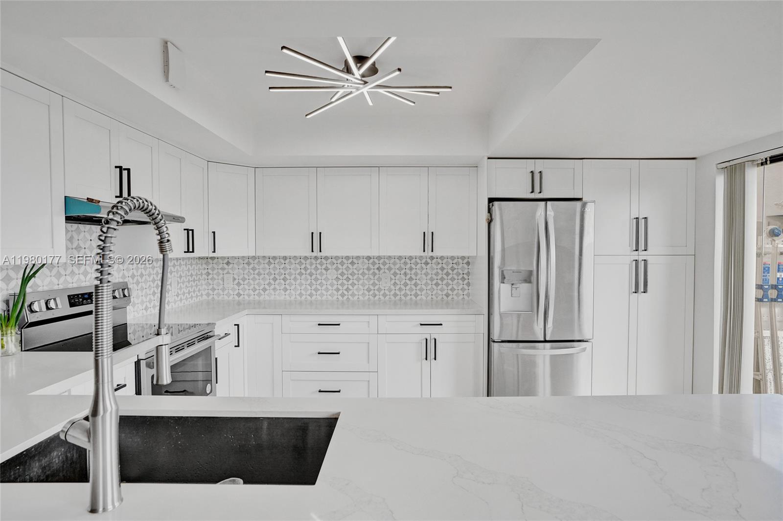A modern kitchen features white cabinets, stainless steel appliances, a patterned backsplash, and quartz countertops — 15292 SW 46th Ln Br # 64, Miami FL 33185, MIAMI, FL