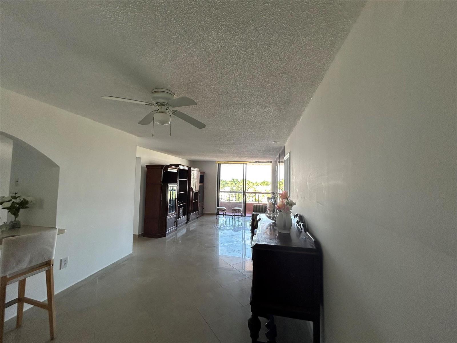 A living room with tile floors, a ceiling fan, and a balcony with outdoor seating — 7040 Coral Way # 501, Miami FL 33155, MIAMI, FL