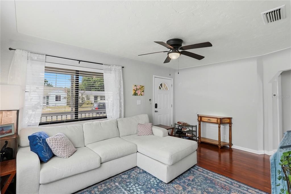 A living room features a white sectional sofa, a ceiling fan, and hardwood flooring — 2850 15TH AVENUE N, ST PETERSBURG, FL