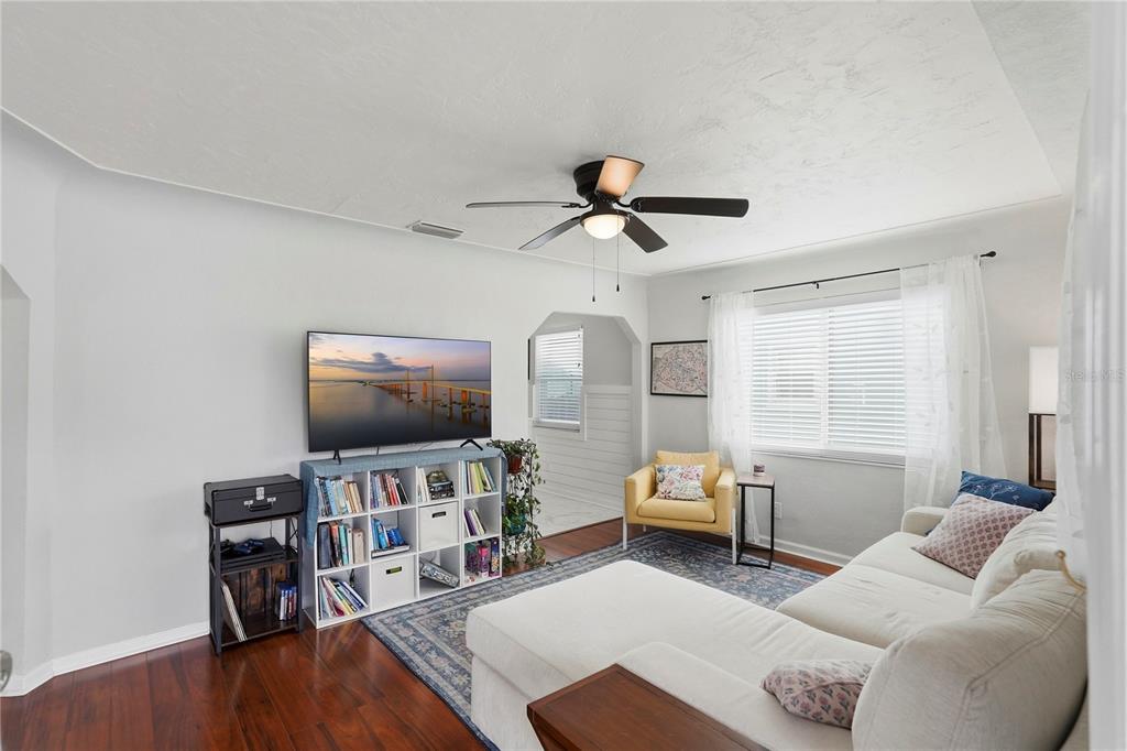 A living room features a white sectional sofa, a television, and a white bookshelf — 2850 15TH AVENUE N, ST PETERSBURG, FL
