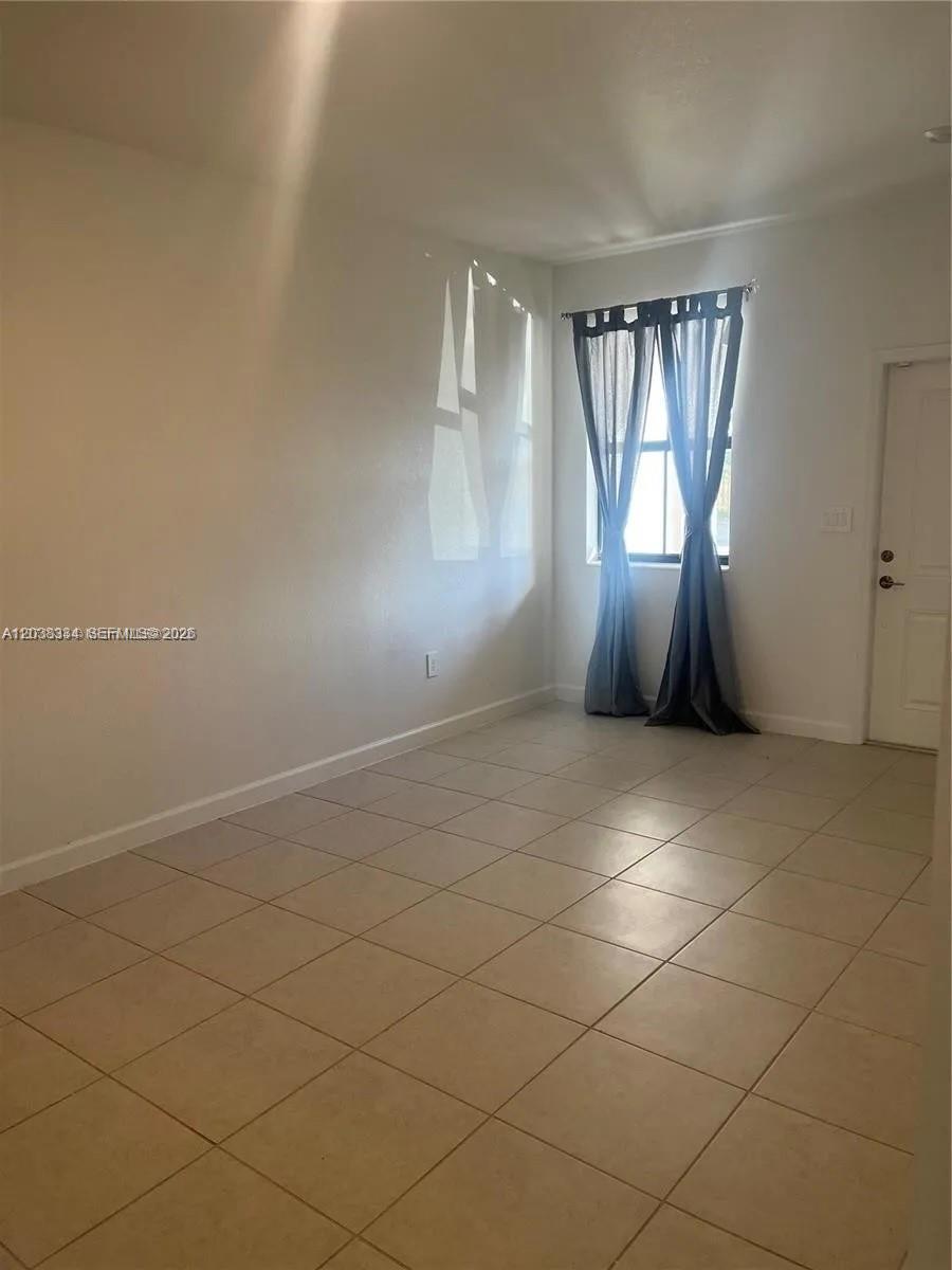 A row of two-story townhouses with beige stucco walls, tile roofs, and attached garages — 11935 SW 246th Ter, Miami FL 33032, MIAMI, FL