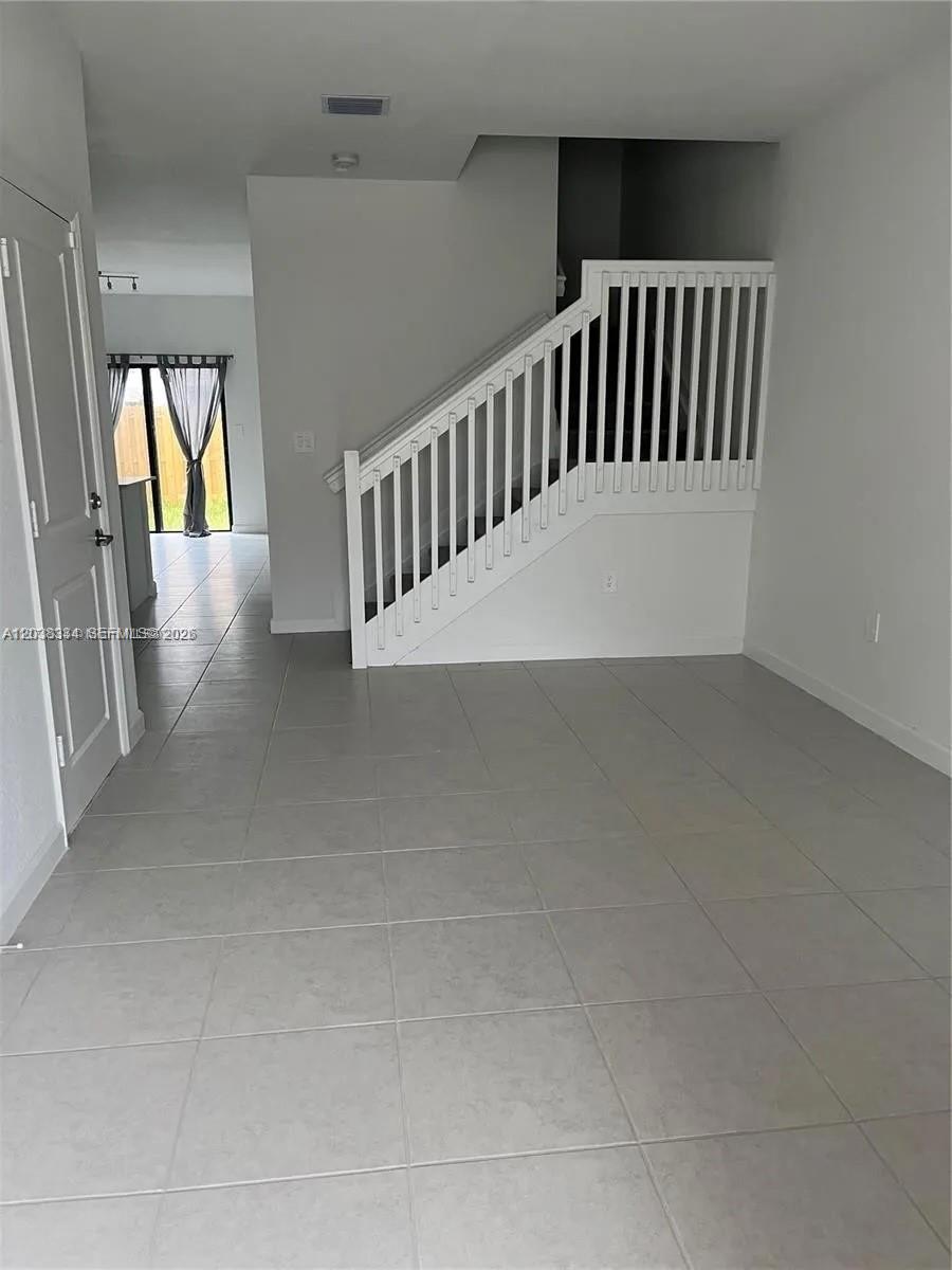 A row of townhouses with tiled roofs sits along a street with parked cars — 11935 SW 246th Ter, Miami FL 33032, MIAMI, FL