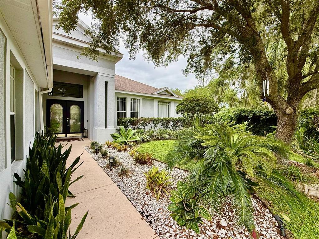 A covered entryway features a dark double door with glass inserts and a transom window — 4301 RIVER CLOSE BOULEVARD, VALRICO, FL