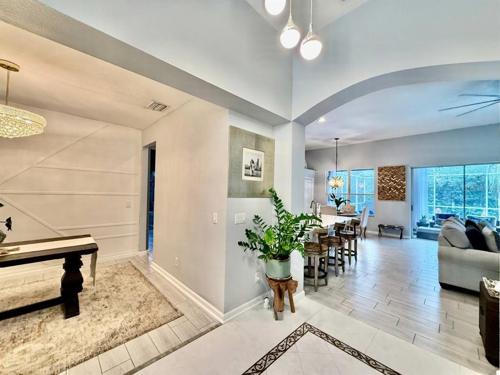 A foyer with tile flooring leads to a living area featuring a marble-tiled fireplace — 4301 RIVER CLOSE BOULEVARD, VALRICO, FL