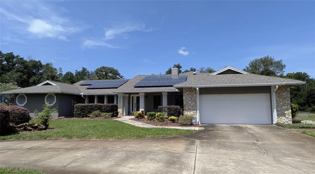 A house exterior features a front porch, a tiled walkway, and solar panels on the roof — 2041 CROWLEY CIRCLE W, LONGWOOD, FL
