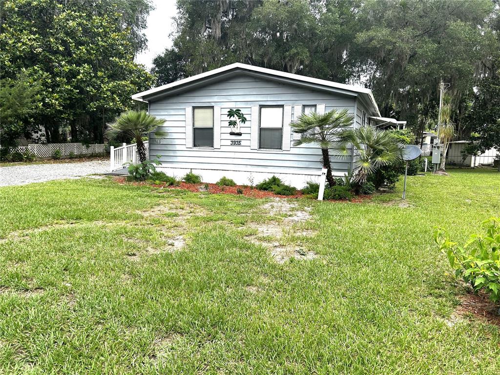 A light blue single-story house with a gabled roof sits on a grassy lot — 3935 E LAKE PARK DRIVE, HERNANDO, FL