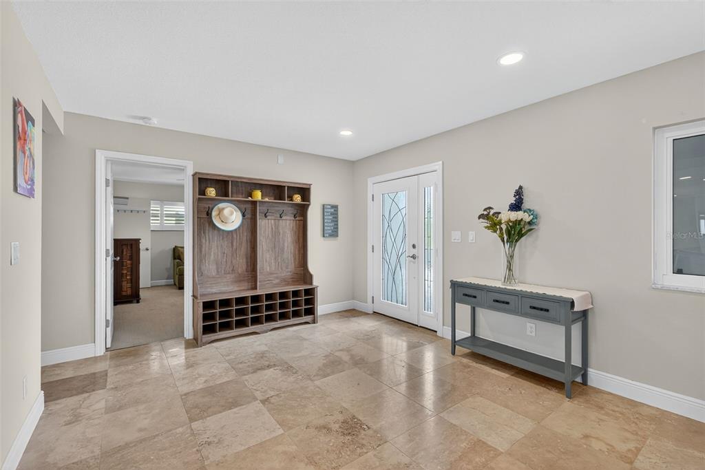 An entryway features tile flooring, a wooden hall tree, and a gray console table — 800 MADONNA BOULEVARD UNIT 1, TIERRA VERDE, FL