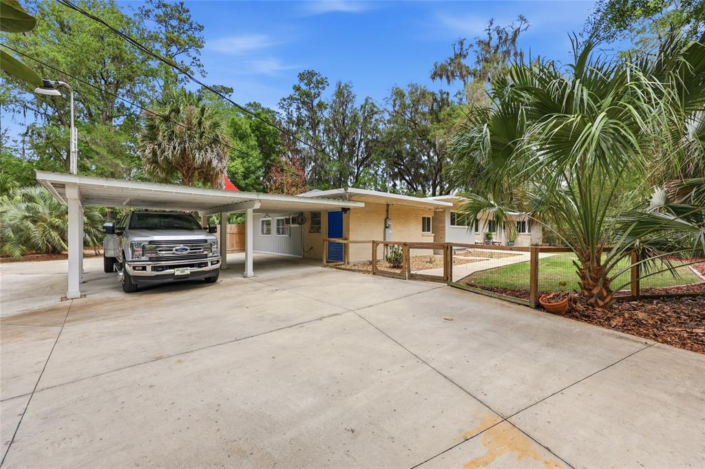 A single-story brick house features a large concrete driveway and a covered carport — 616 SW 21ST AVENUE, GAINESVILLE, FL