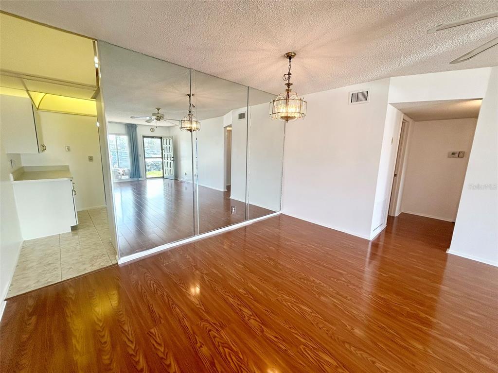 A dining area with wood flooring, a mirrored wall, and a hanging chandelier — 2400 COLUMBIA DRIVE UNIT 18, CLEARWATER, FL