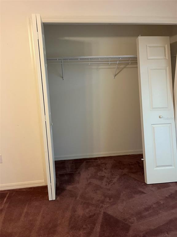 A closet with a wire shelf and white bifold doors sits in a carpeted room — 8451 SW 14TH LANE, OKEECHOBEE, FL